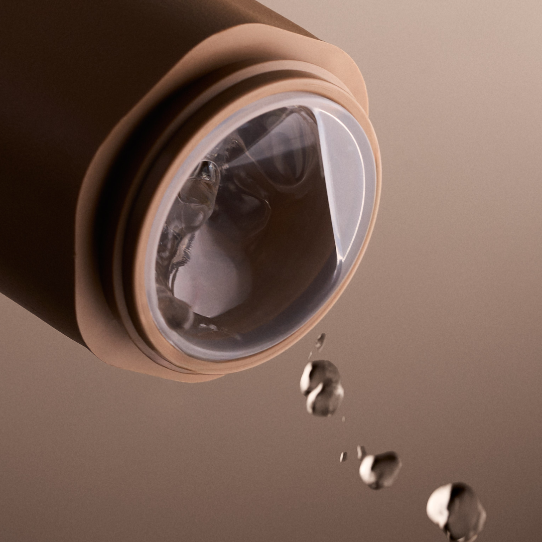 Close-up of a coffee maker with water droplets on a brown background