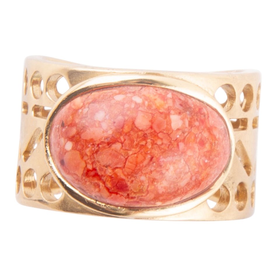 Gold ring with a pink stone on a white background