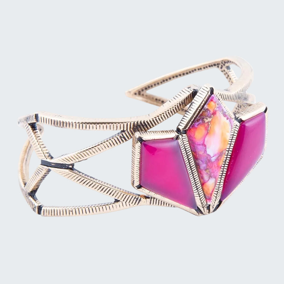 Cuff bracelet with pink and orange geometric stones on a white background
