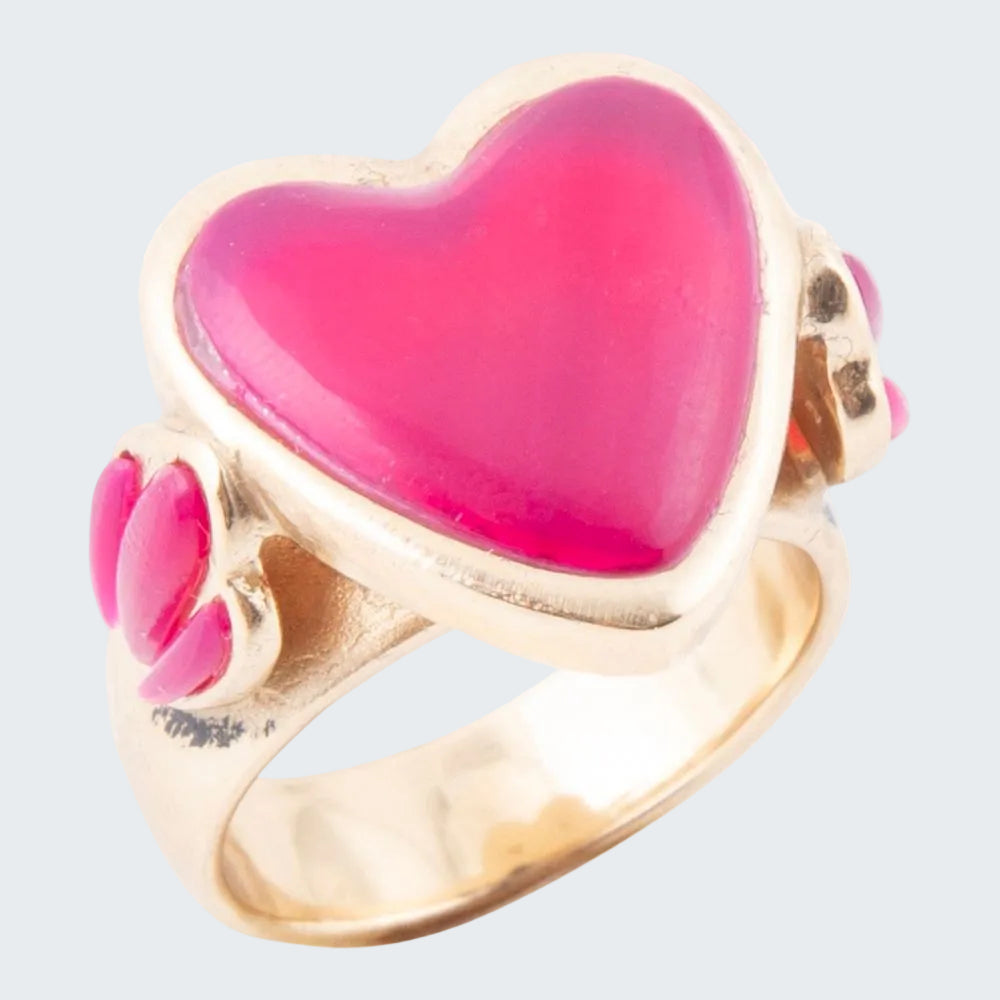 Gold ring with a pink heart-shaped stone on a white background