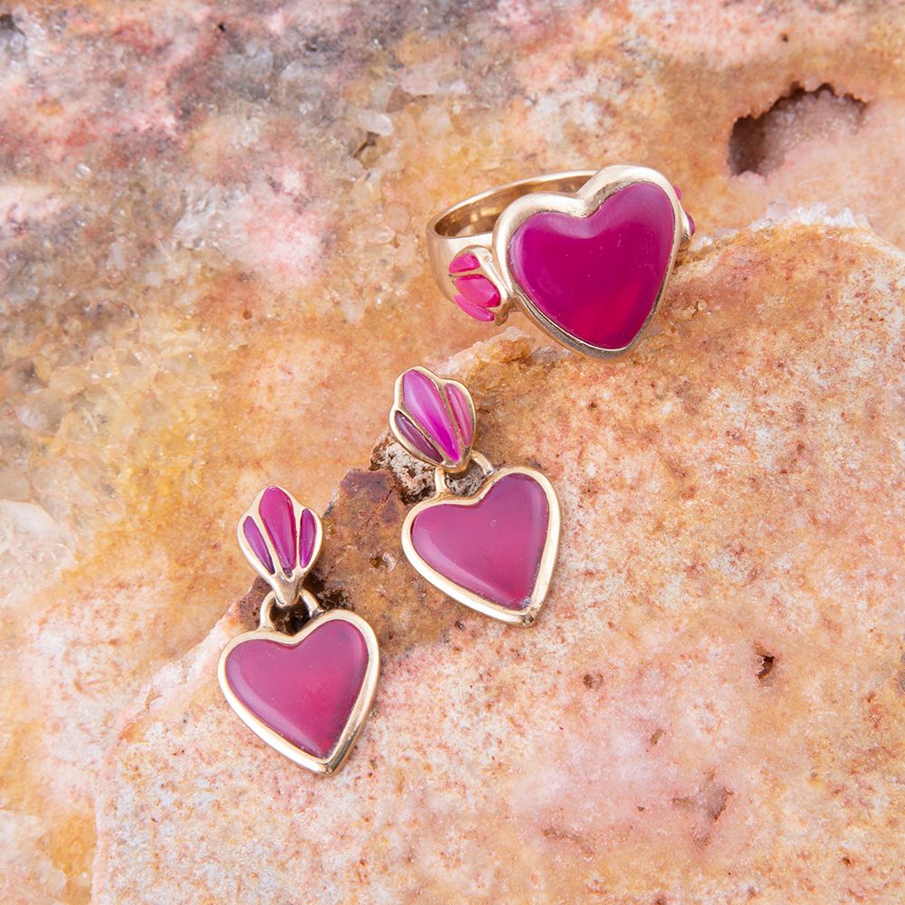 Heart-shaped jewelry set with pink hearts on a stone background