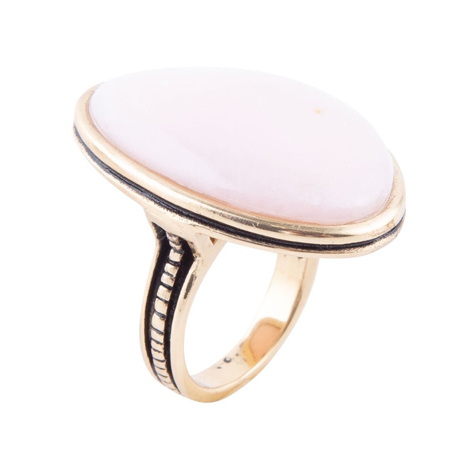 Ring with a pink stone and gold band on a white background