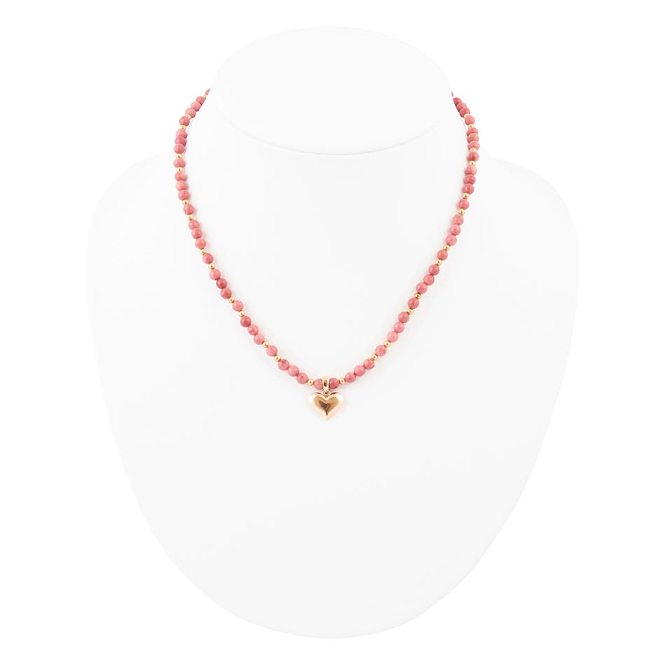 Necklace with pink beads and a gold heart charm on a white background