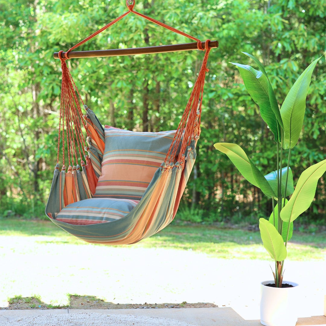 Colorful hammock chair with striped cushions in a garden setting