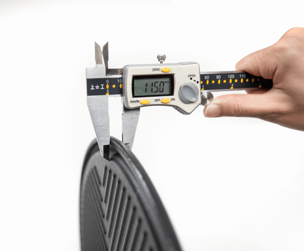 Digital caliper measuring a bicycle tire on a white background