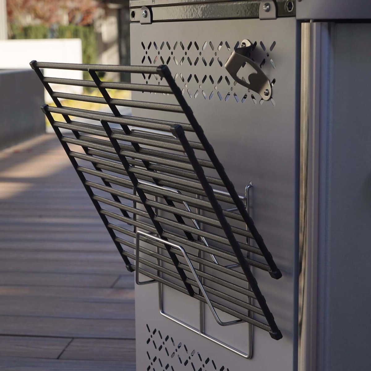 Metal cooling rack attached to a refrigerator on a wooden deck