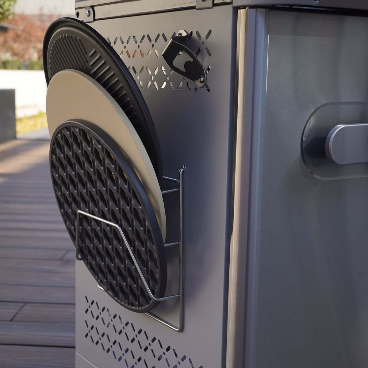 Close-up of a grill with a metal rack holding three ceramic grates.