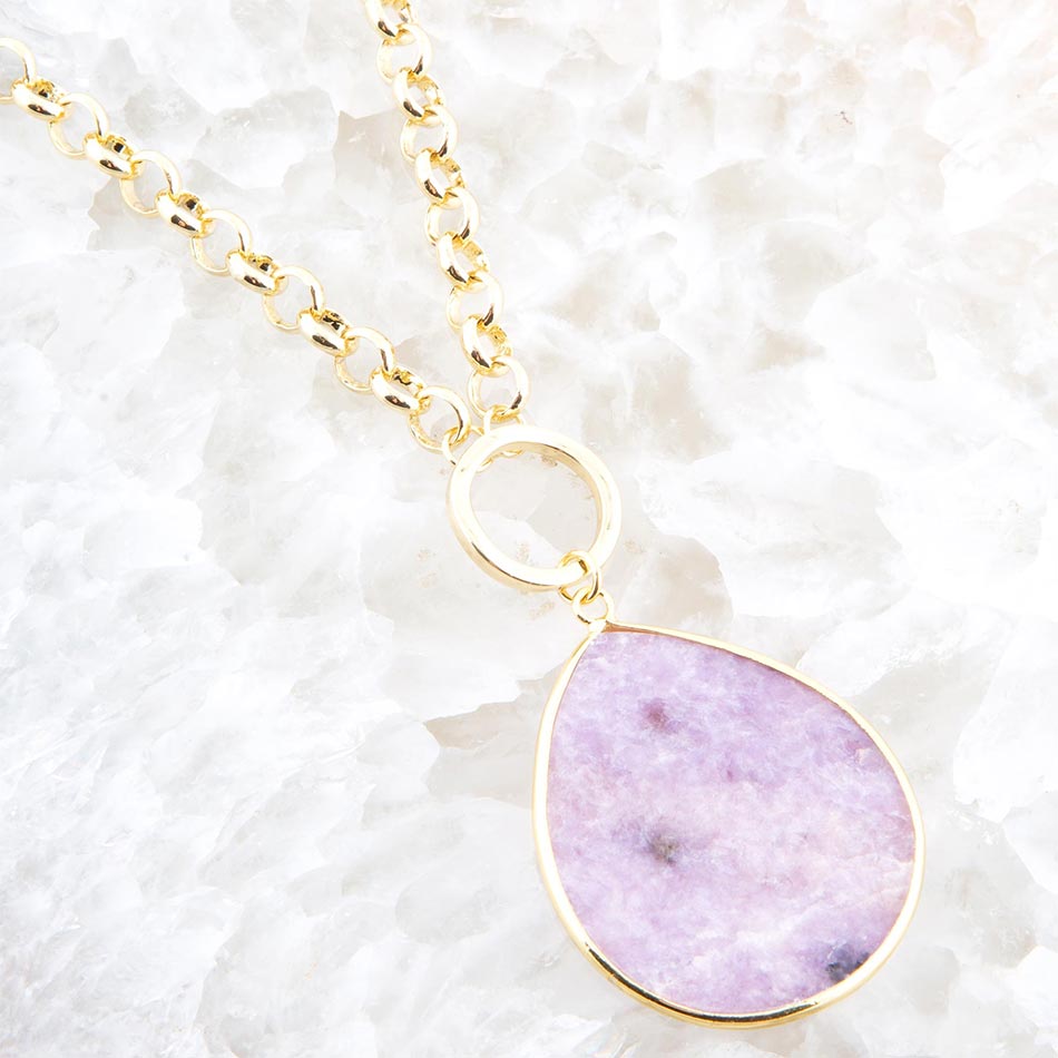 Necklace with a purple pendant on a textured white background