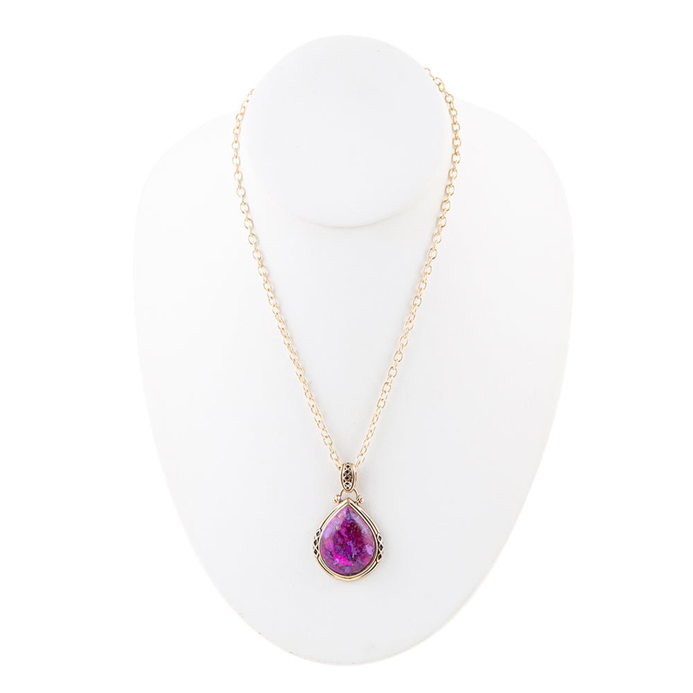 Necklace with a purple teardrop pendant on a white stand