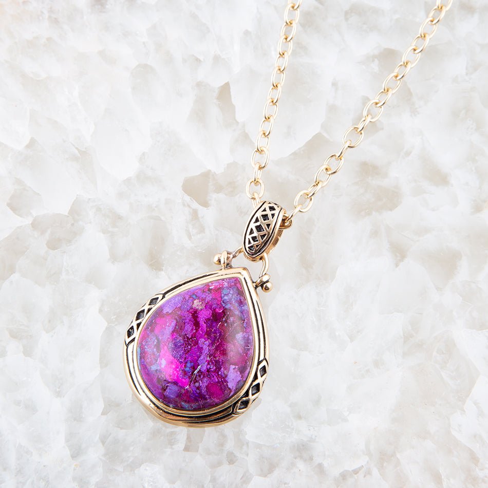 Necklace with a pink teardrop pendant on a white textured background