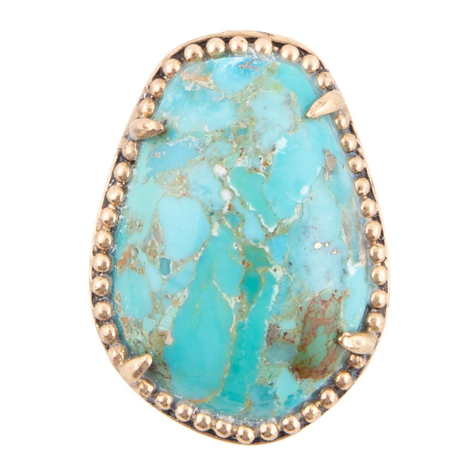 Turquoise stone ring with gold beaded setting on a white background