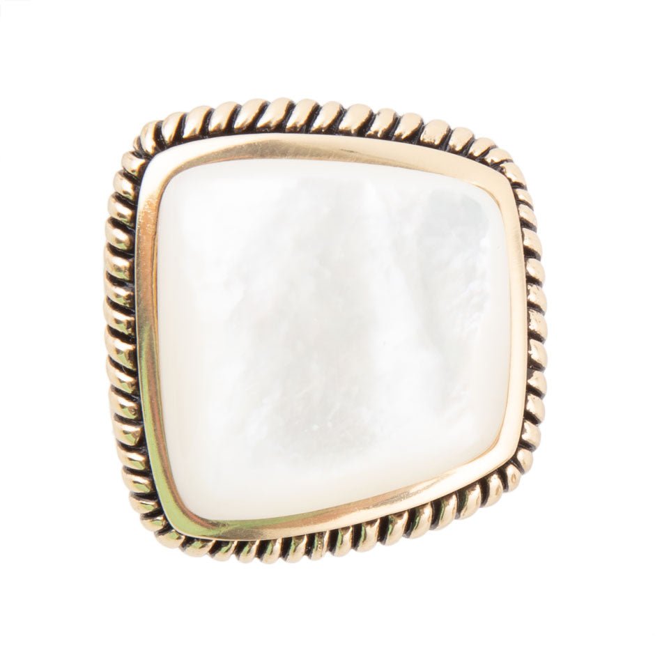 Gold-rimmed ring with a square white stone on a white background