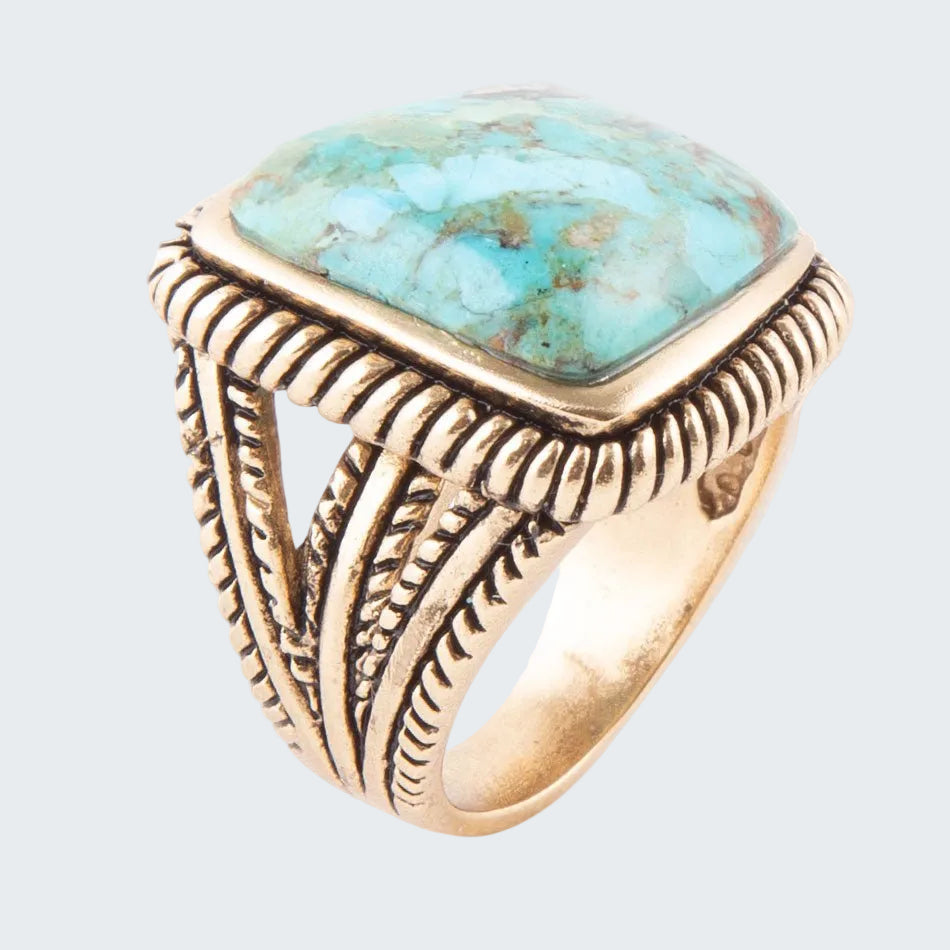 Gold ring with turquoise stone on a white background