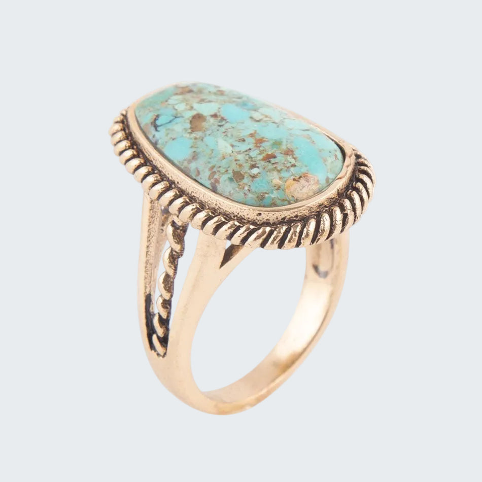 Turquoise stone ring with gold band on a white background