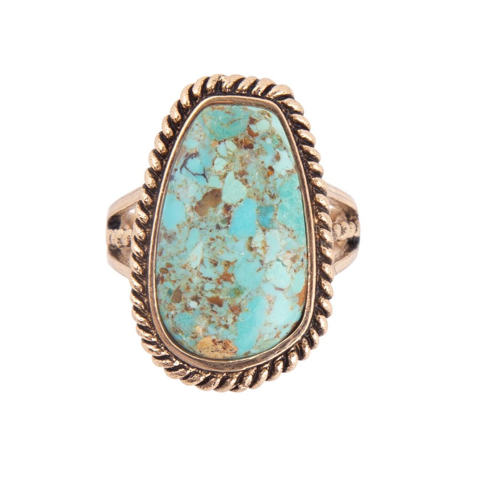 Ring with turquoise stone and gold-tone band on a white background
