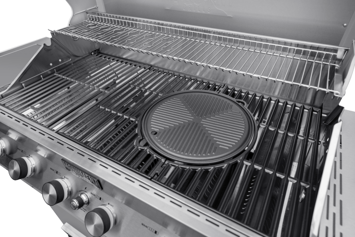 Close-up of a gas grill with multiple burners and grates on a green background