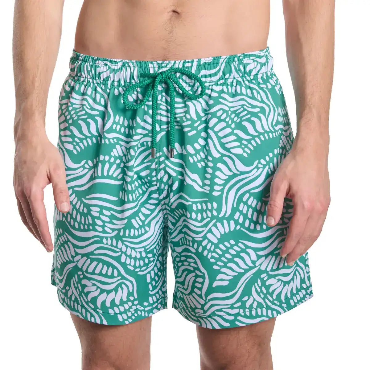 Green and white patterned swim shorts on a white background