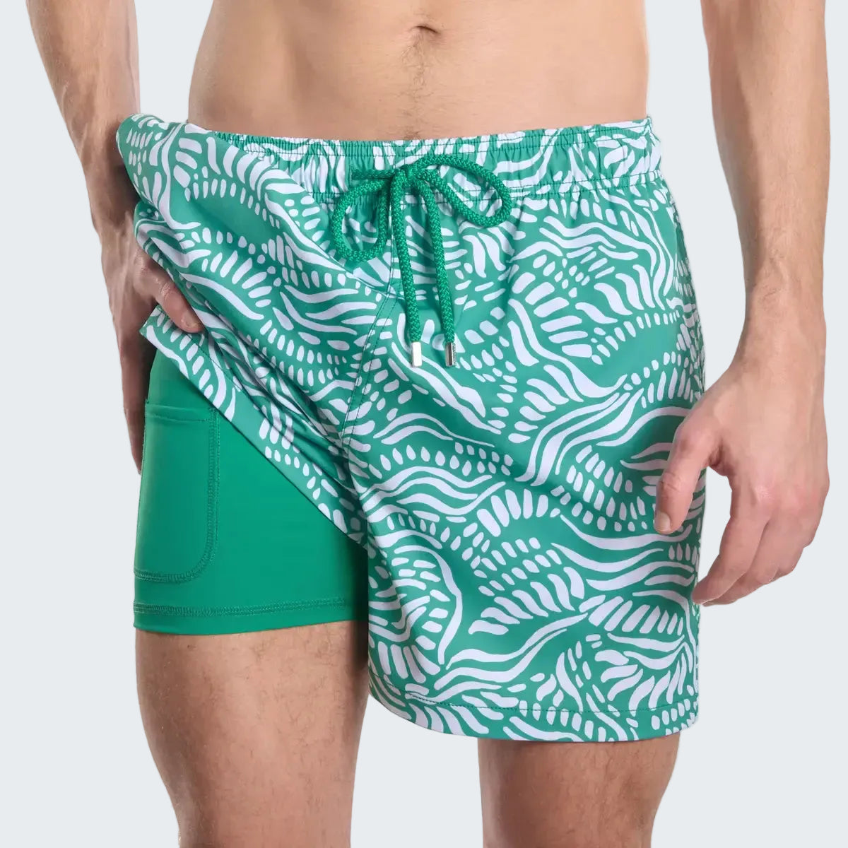 Green swim shorts with white pattern on a white background