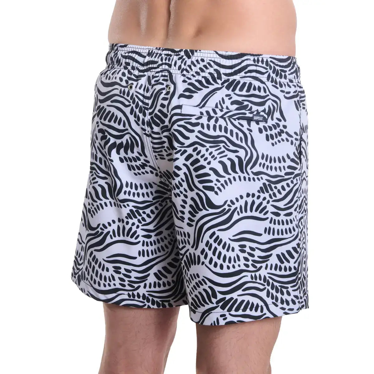 Black and white patterned swim shorts on a plain background