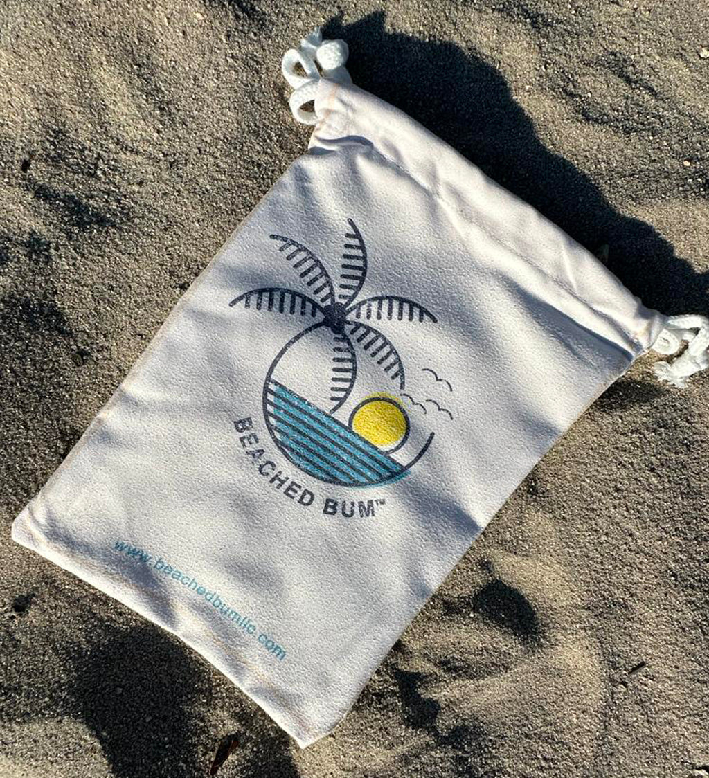 Beached Bum drawstring bag on a sandy surface