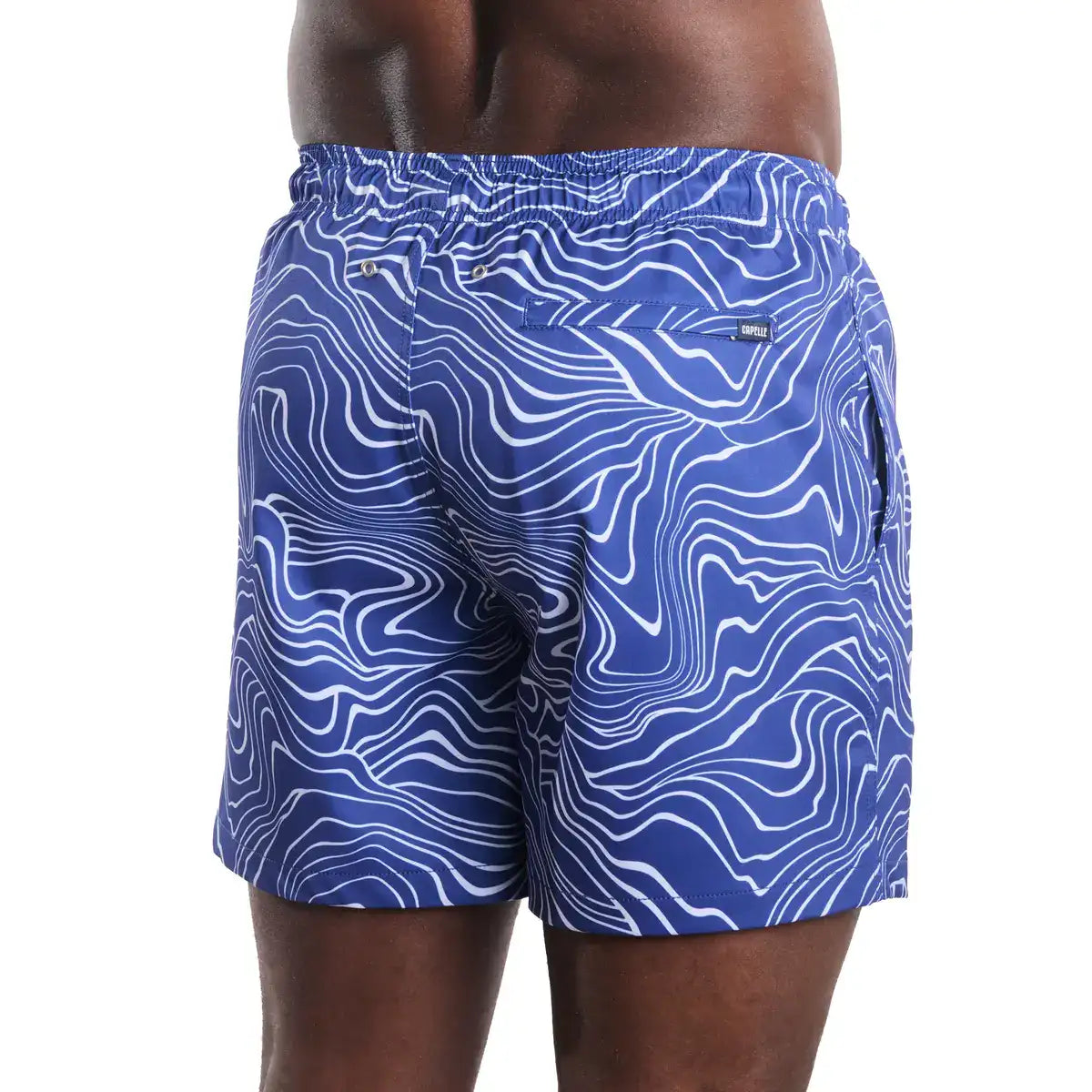 Blue swim shorts with white pattern worn by a person on a white background