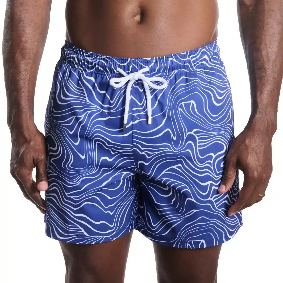 Blue swim shorts with white pattern worn by a person on a white background