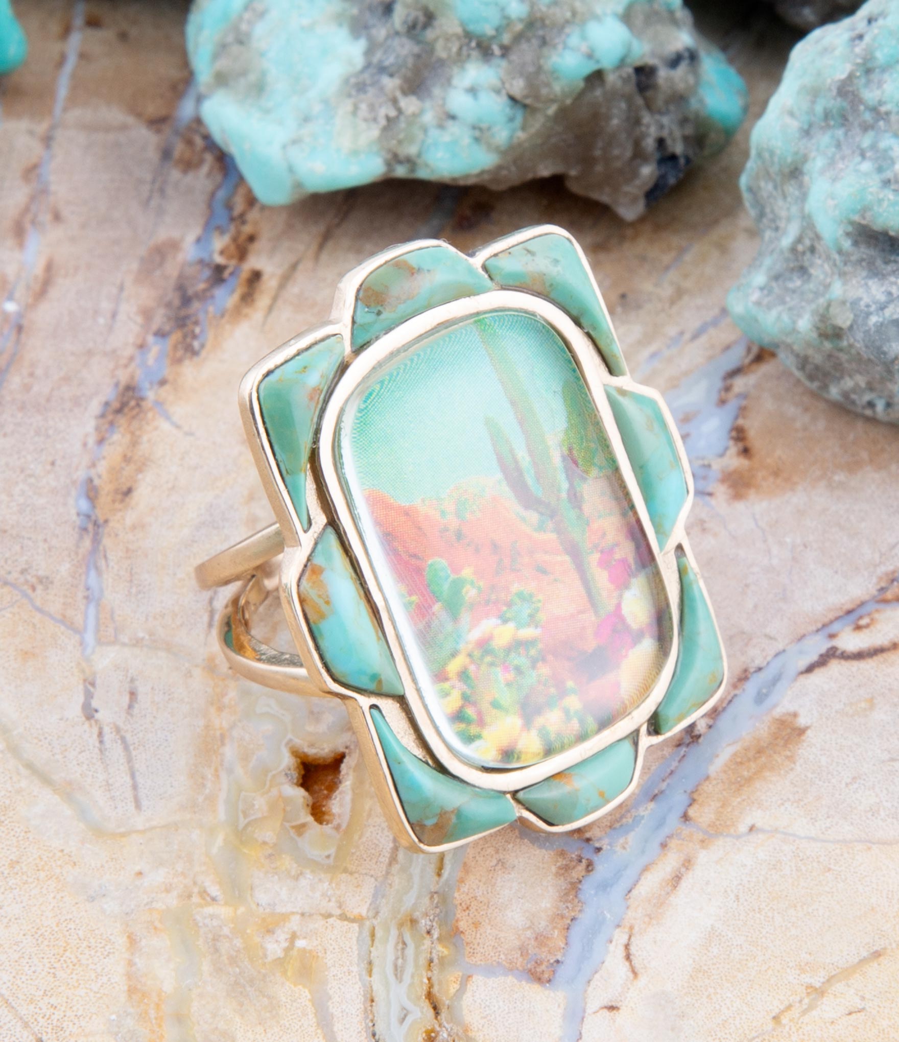 Turquoise stone ring with gold frame on a stone surface