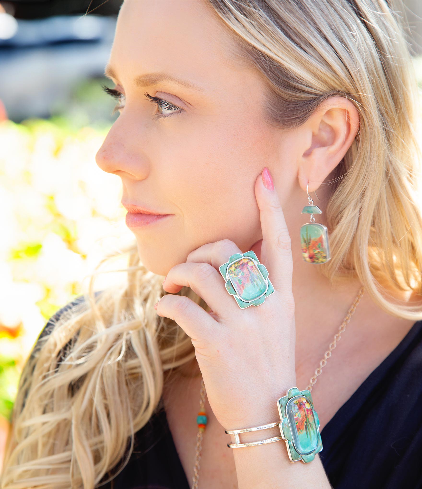 Woman wearing colorful jewelry with a blurred outdoor background