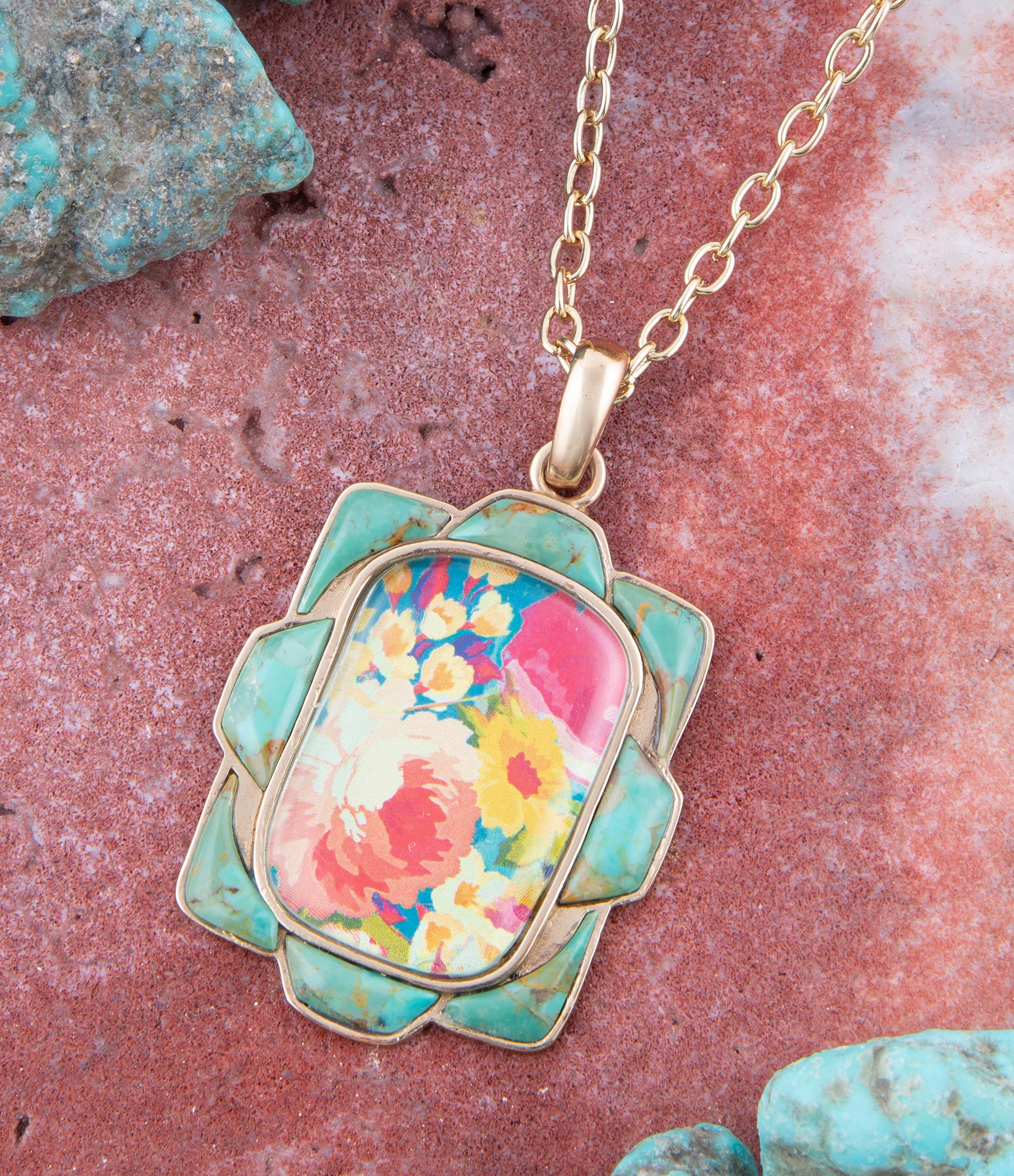 Necklace with a colorful floral pendant on a textured pink and green background
