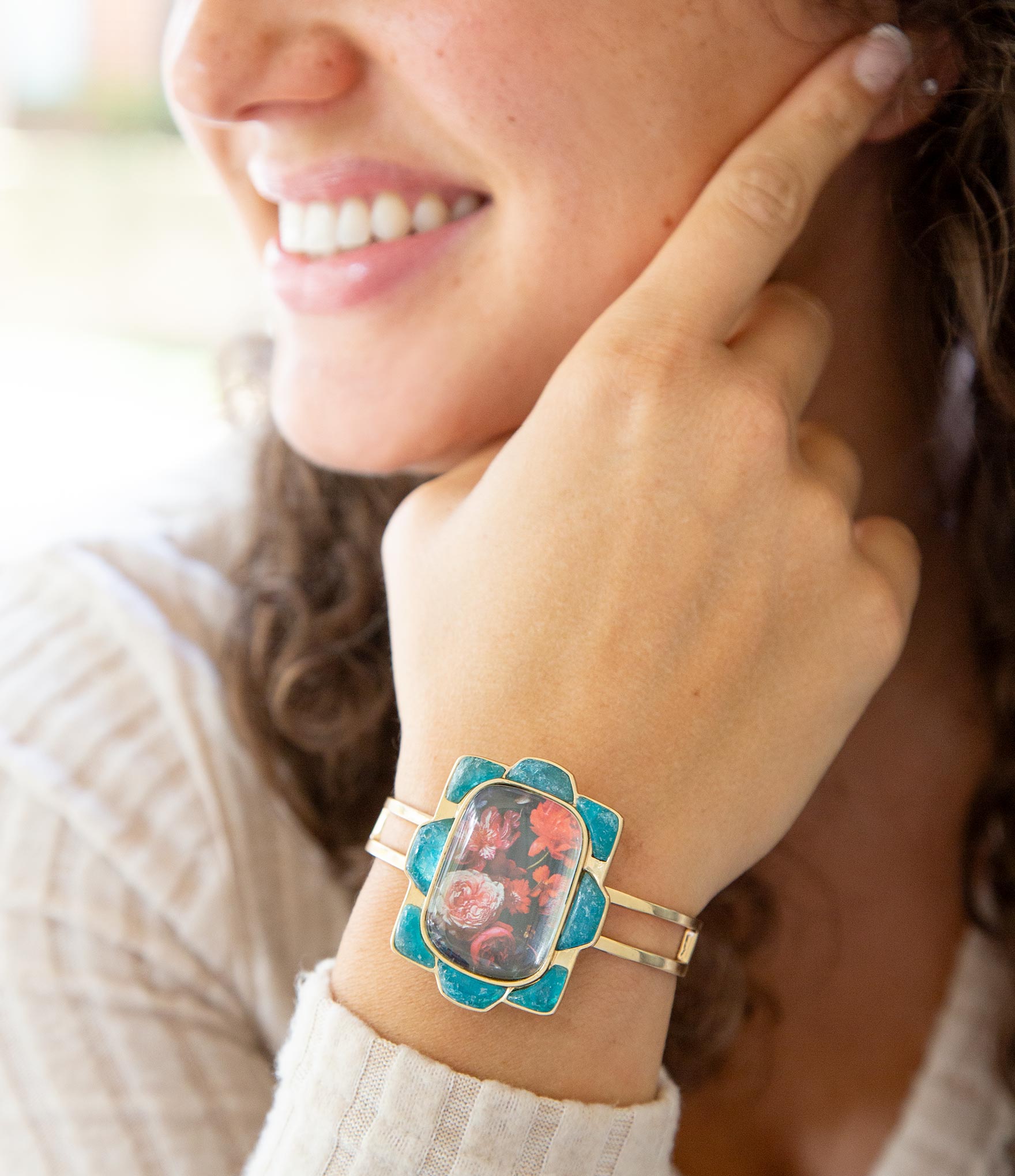 Woman wearing a decorative bracelet on her wrist with a floral design.