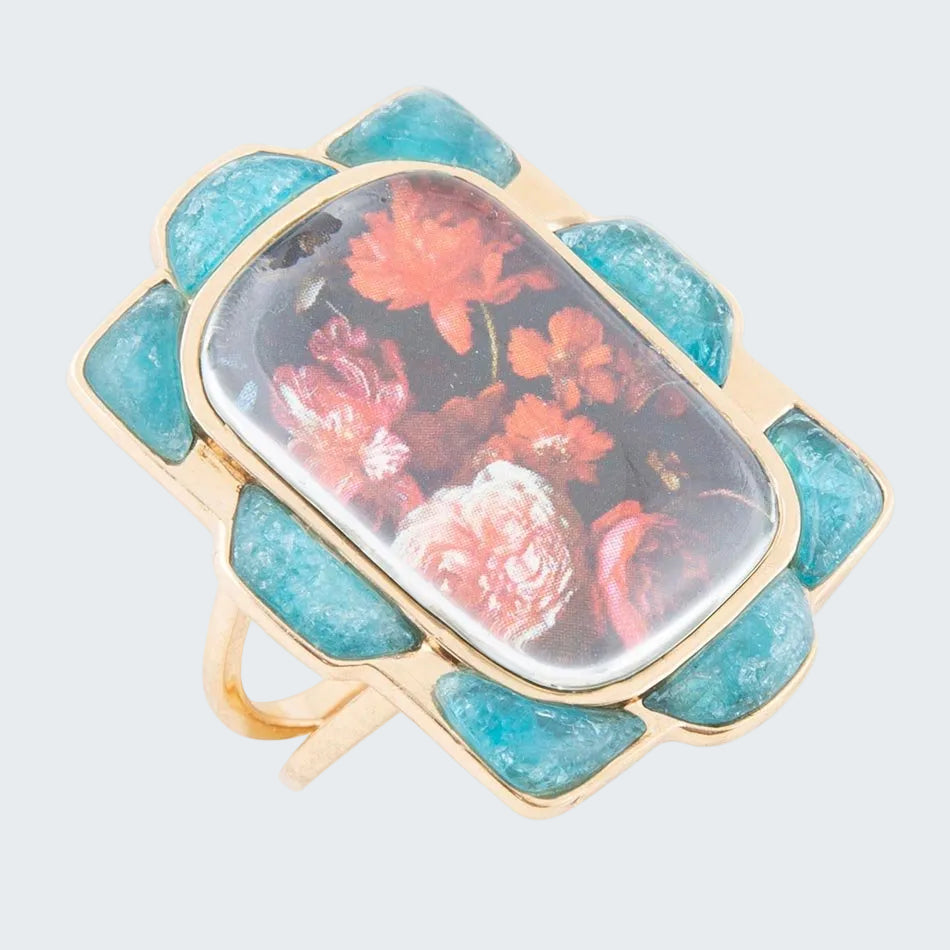Ring with turquoise stones and floral design on a white background