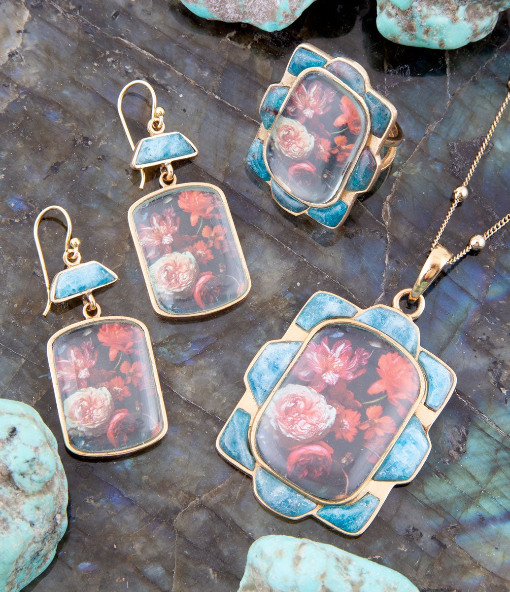 Jewelry set with floral designs on a dark stone surface
