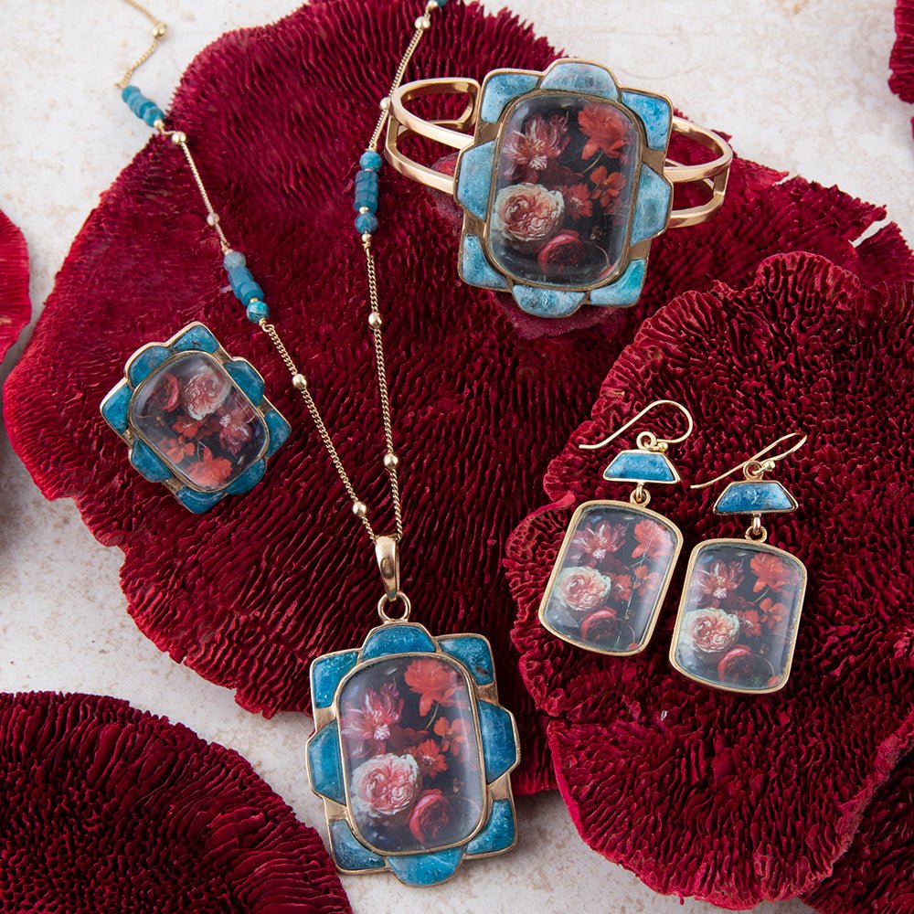 Jewelry set with floral designs on a textured red surface