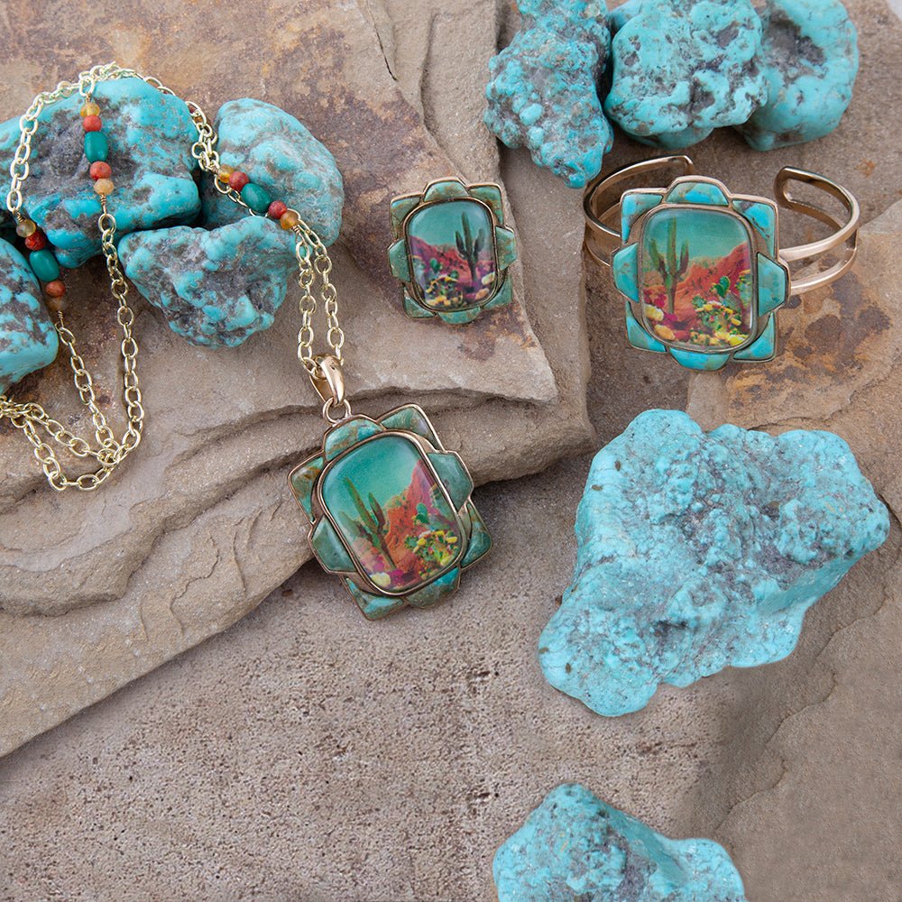 Jewelry set with turquoise stones and colorful desert scene design on a stone surface