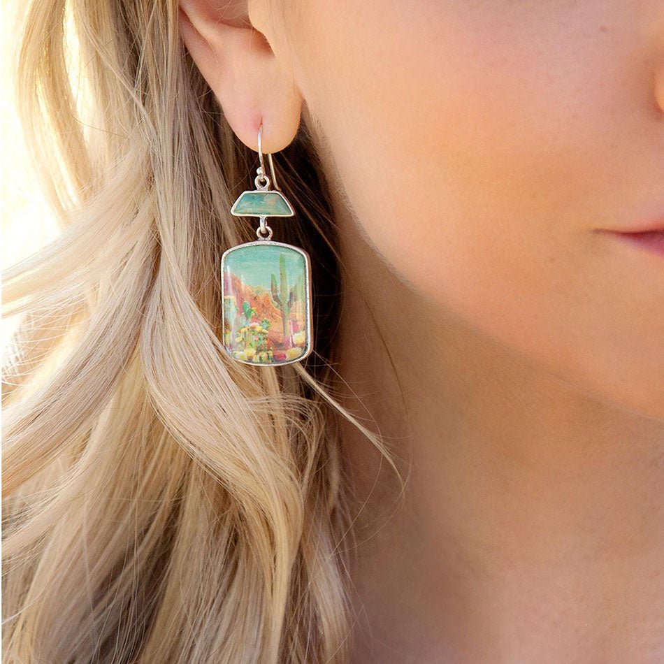Close-up of a woman wearing a colorful earring with blonde hair.