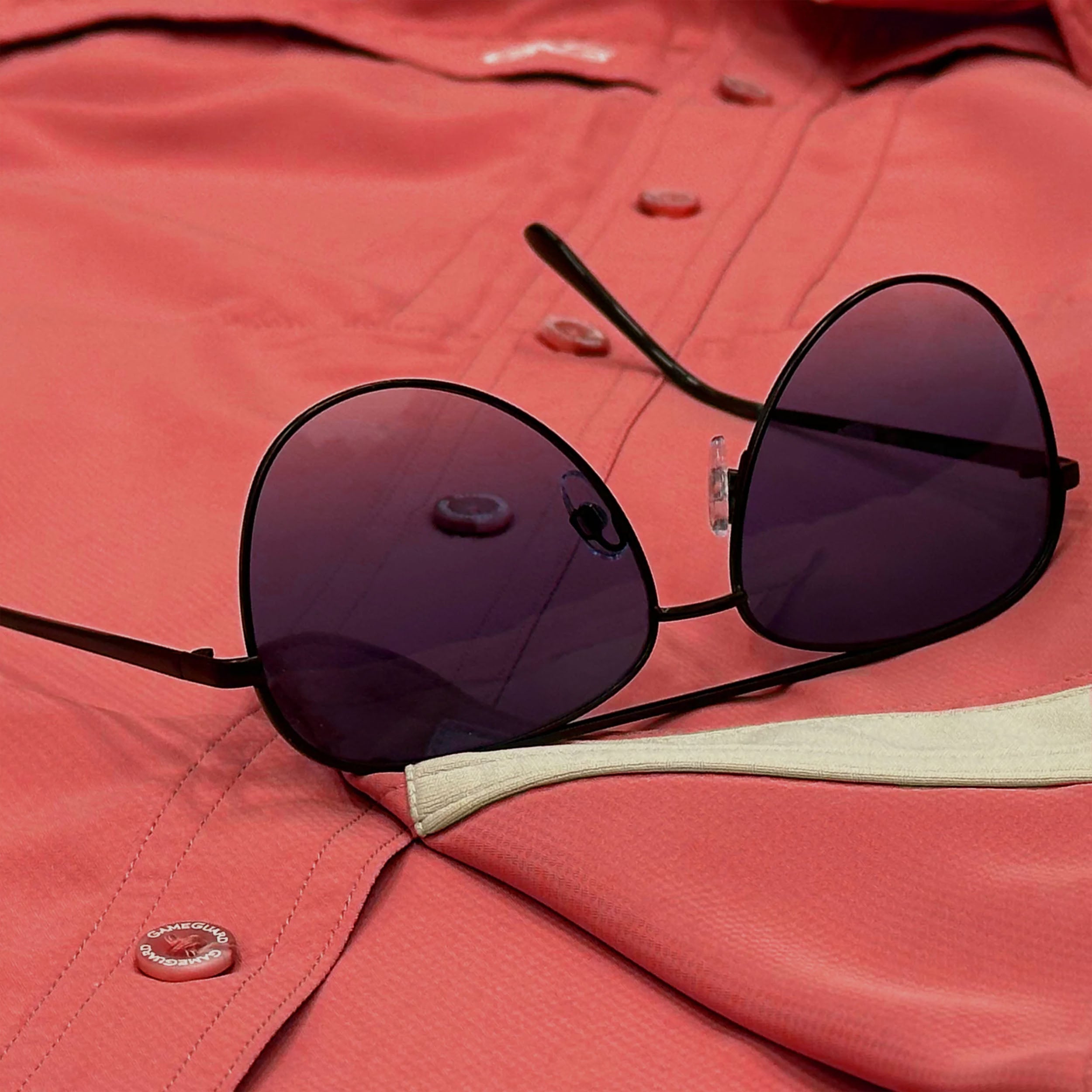 Sunglasses on a red shirt with a close-up view