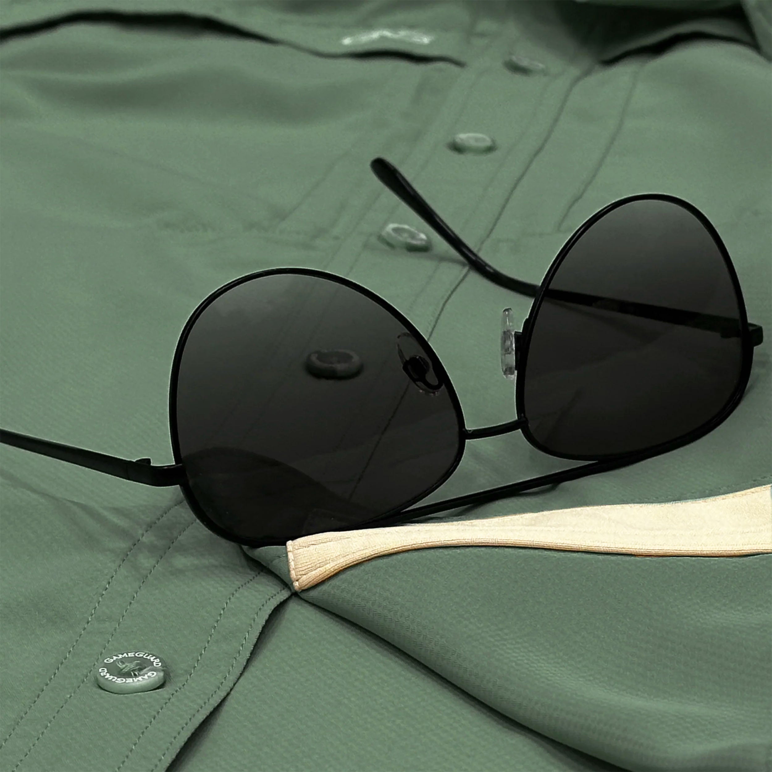 Black sunglasses on a green shirt