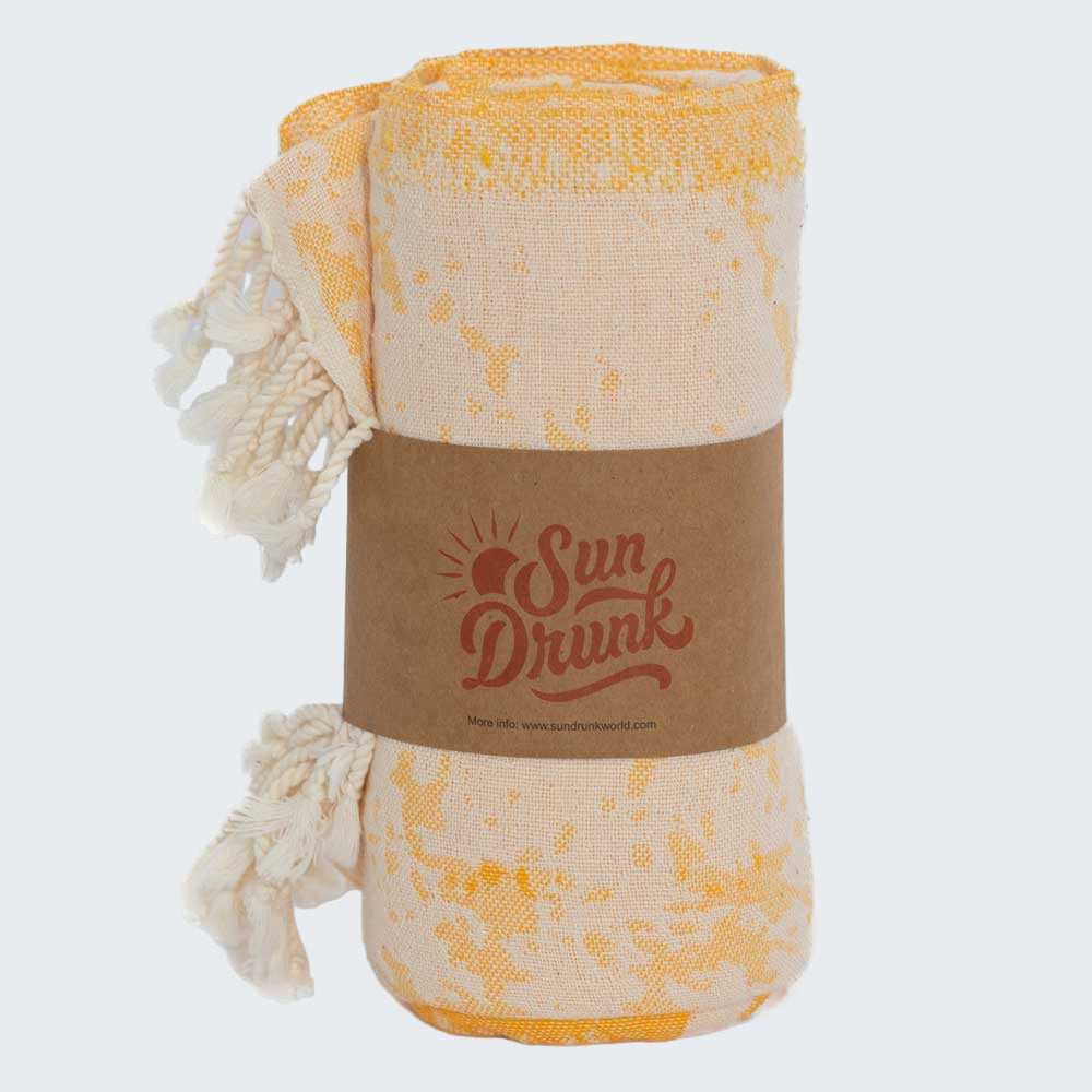 Yellow and white patterned towel with a brown label on a white background