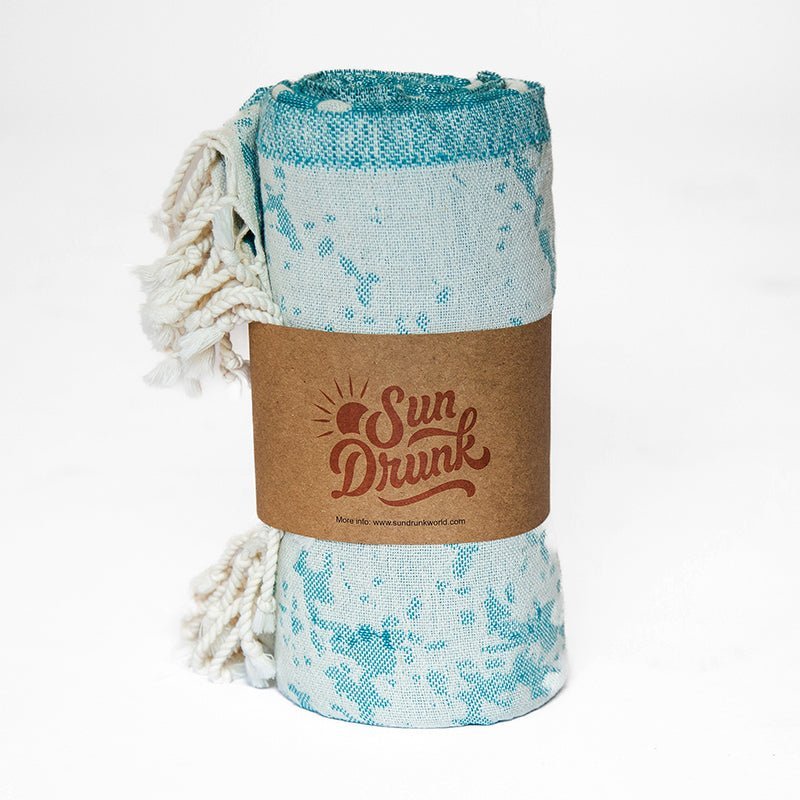 Teal patterned towel with a brown label on a white background