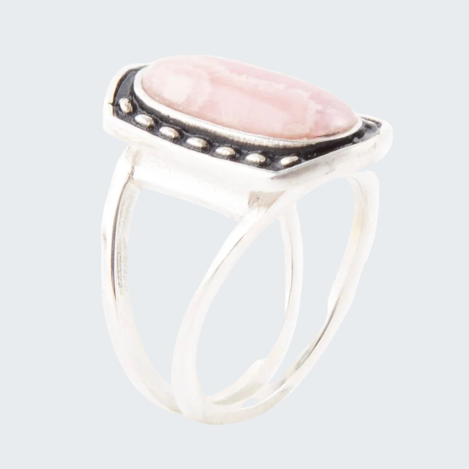 Silver ring with a pink stone on a white background