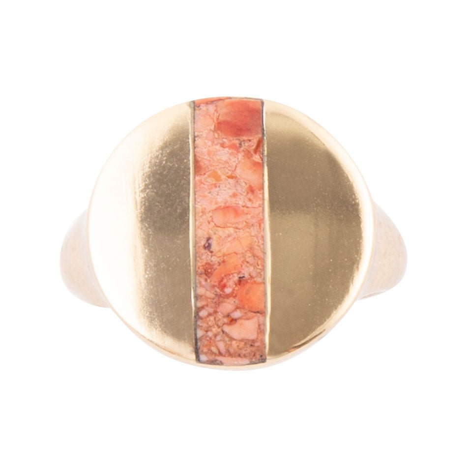 Gold ring with a central coral-colored stone on a white background