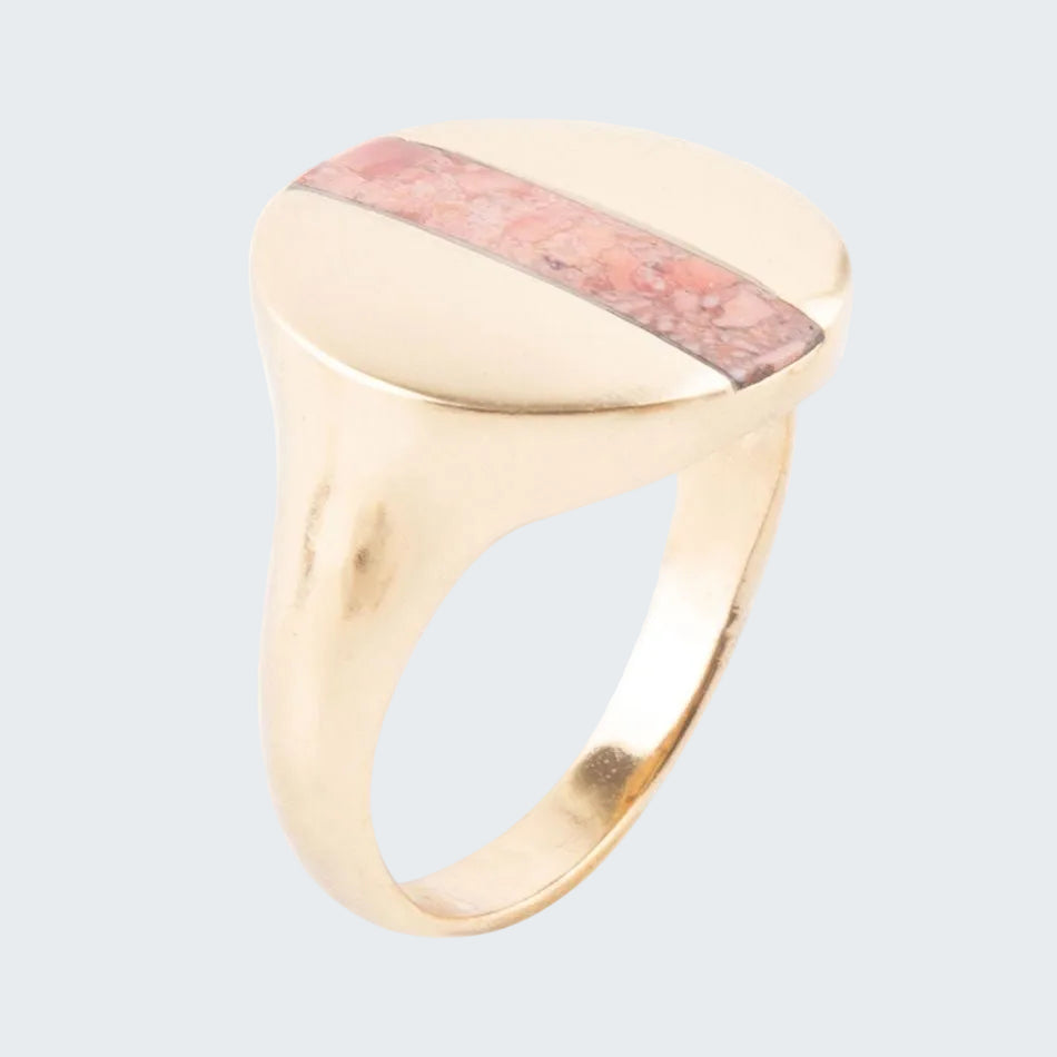 Gold ring with a pink stone on a white background