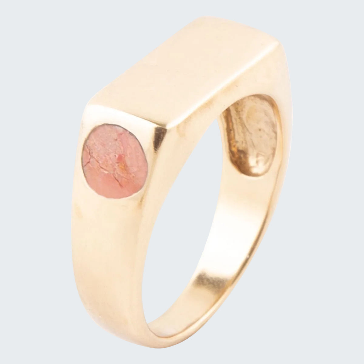 Gold ring with a pink stone on a white background