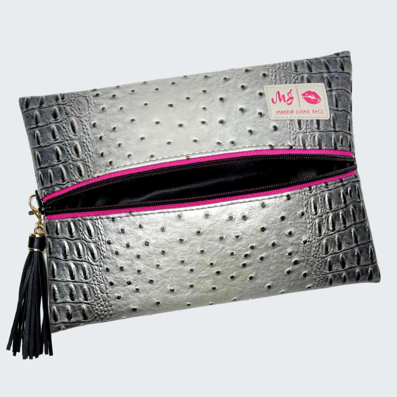 Silver textured clutch with pink interior and tassel on a white background