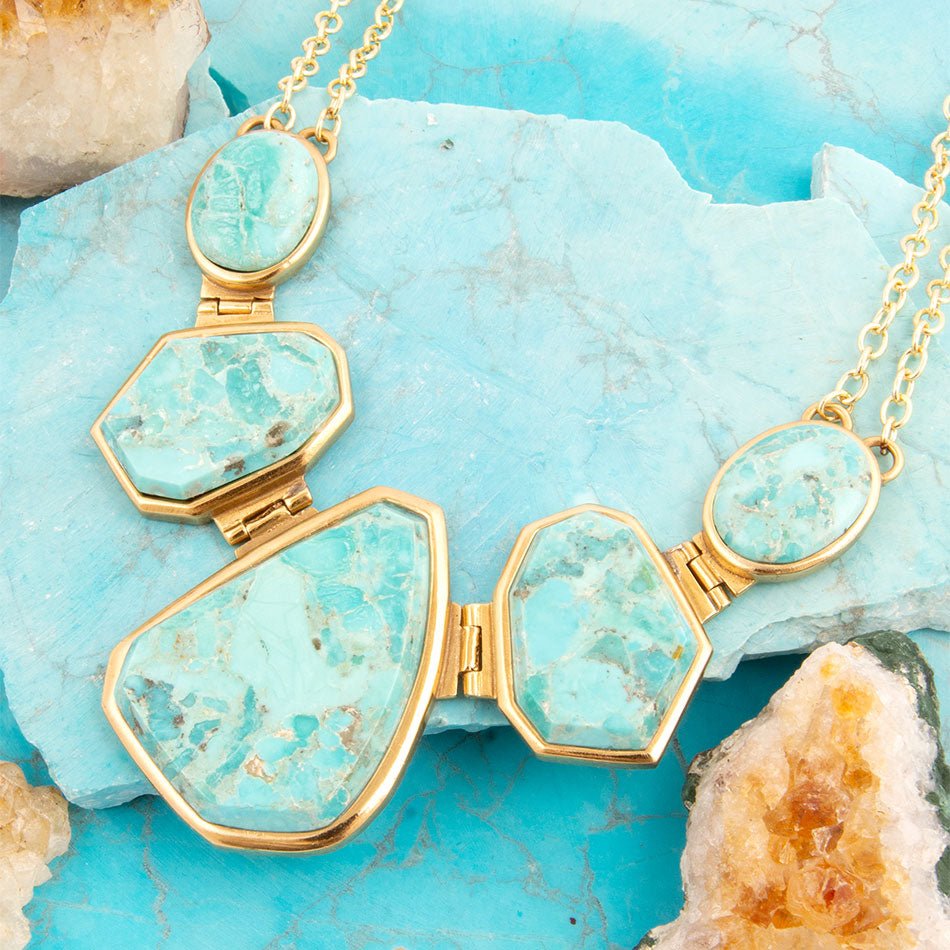 Turquoise stone necklace with gold frame on a turquoise stone background
