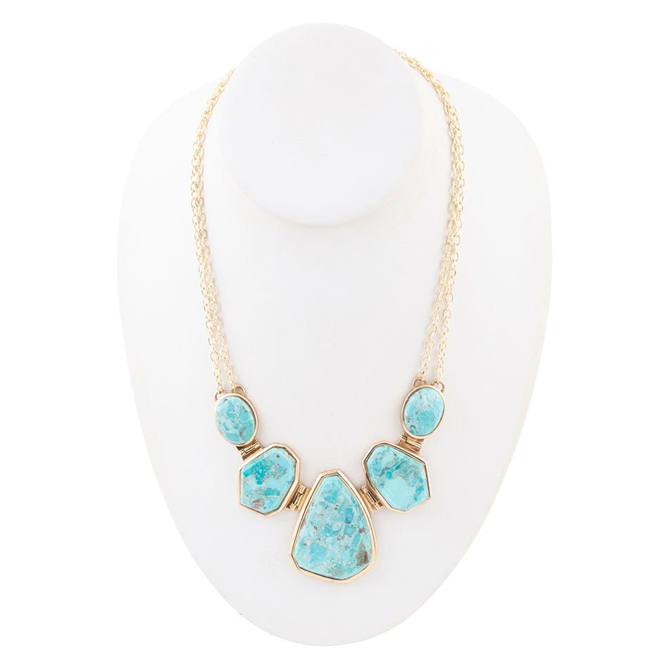 Necklace with turquoise stones on a white stand
