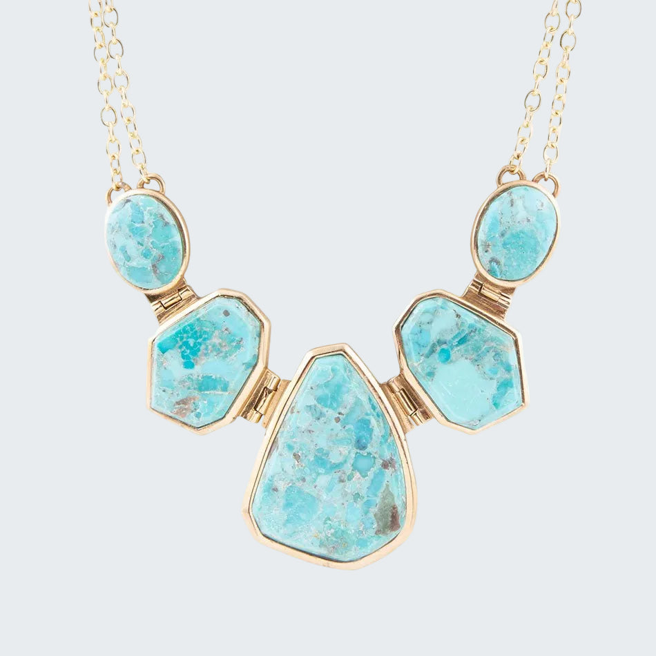 Necklace with turquoise stones and gold accents on a white background