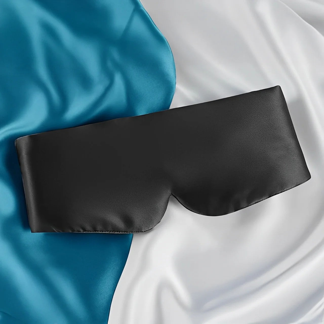 Black satin eye mask on a blue and white satin background
