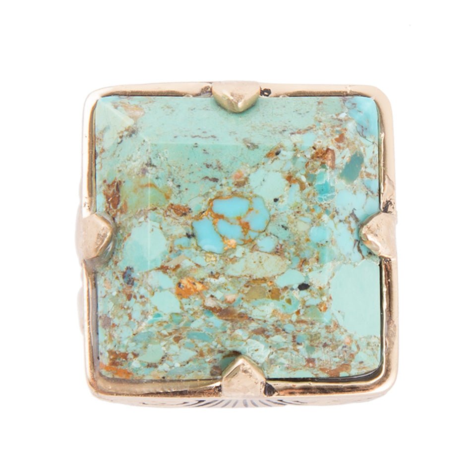 Turquoise stone ring with gold frame on white background