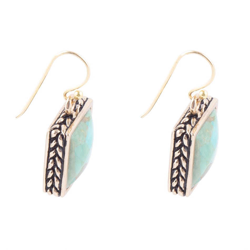 Pair of earrings with turquoise stones and gold accents on a white background